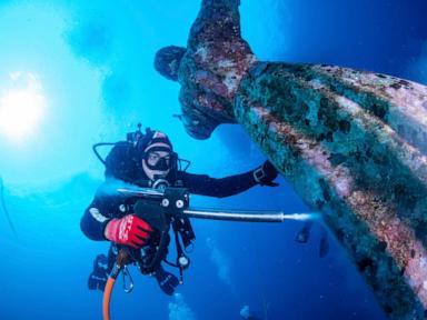  Italian divers water-blast the popular underwater statue of Christ off Portofino to clean it