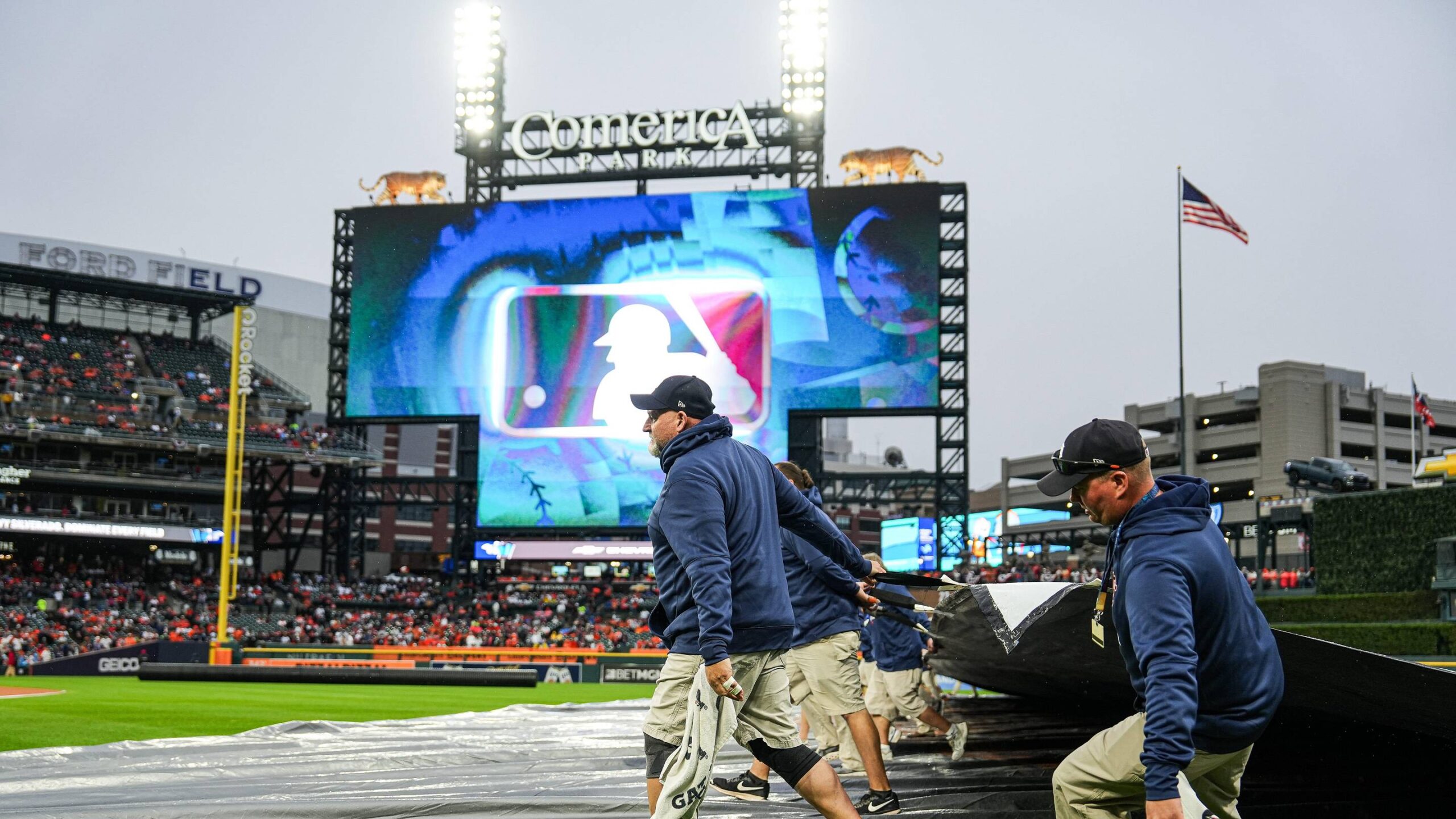 The Detroit Tigers’ grounds crew removes the tarp from the field after the rain delay.