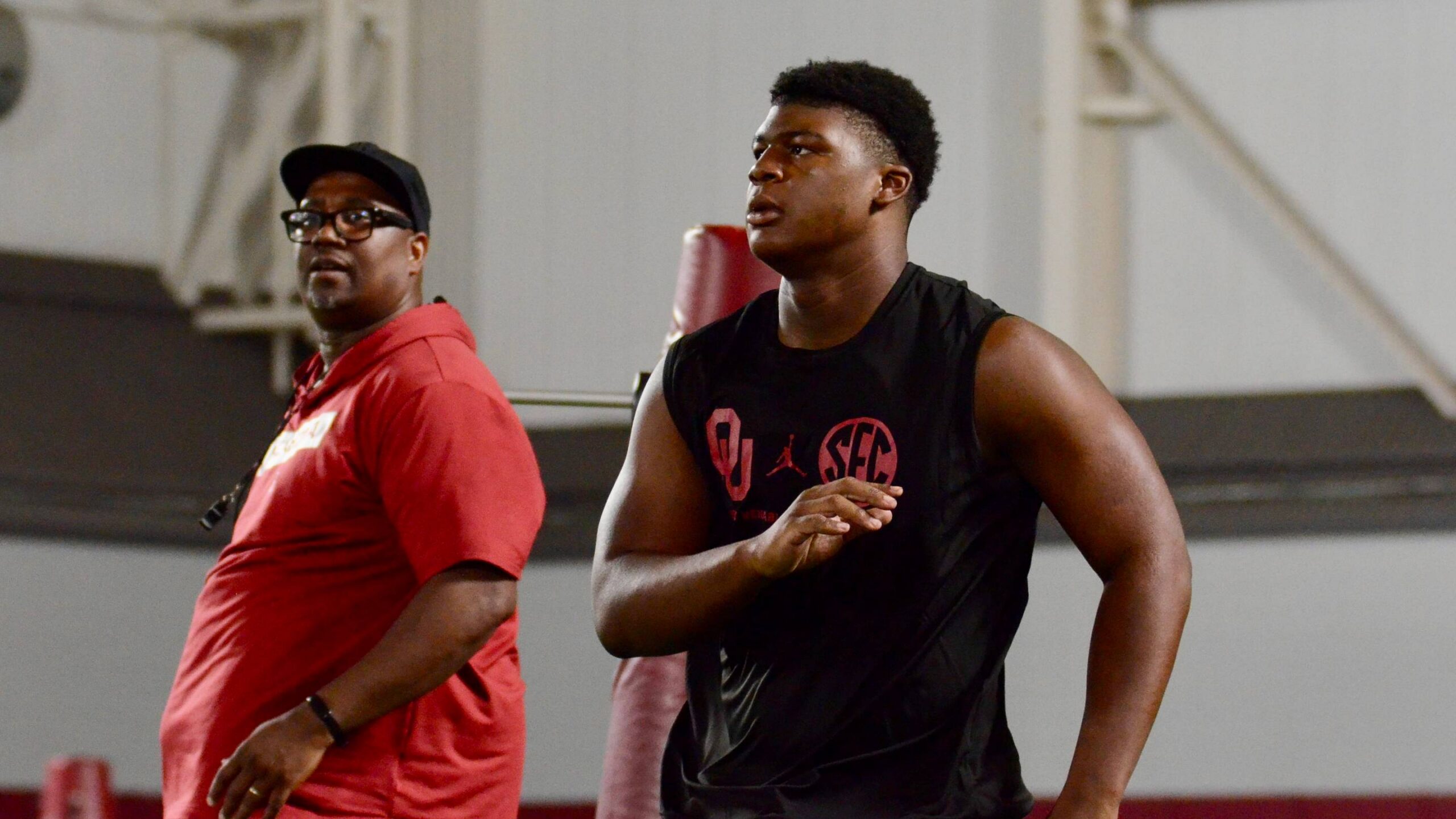 Oklahoma defensive tackle prospect Kellan Hall goes through a drill with defensive tackles coach Todd Bates watching at camp.