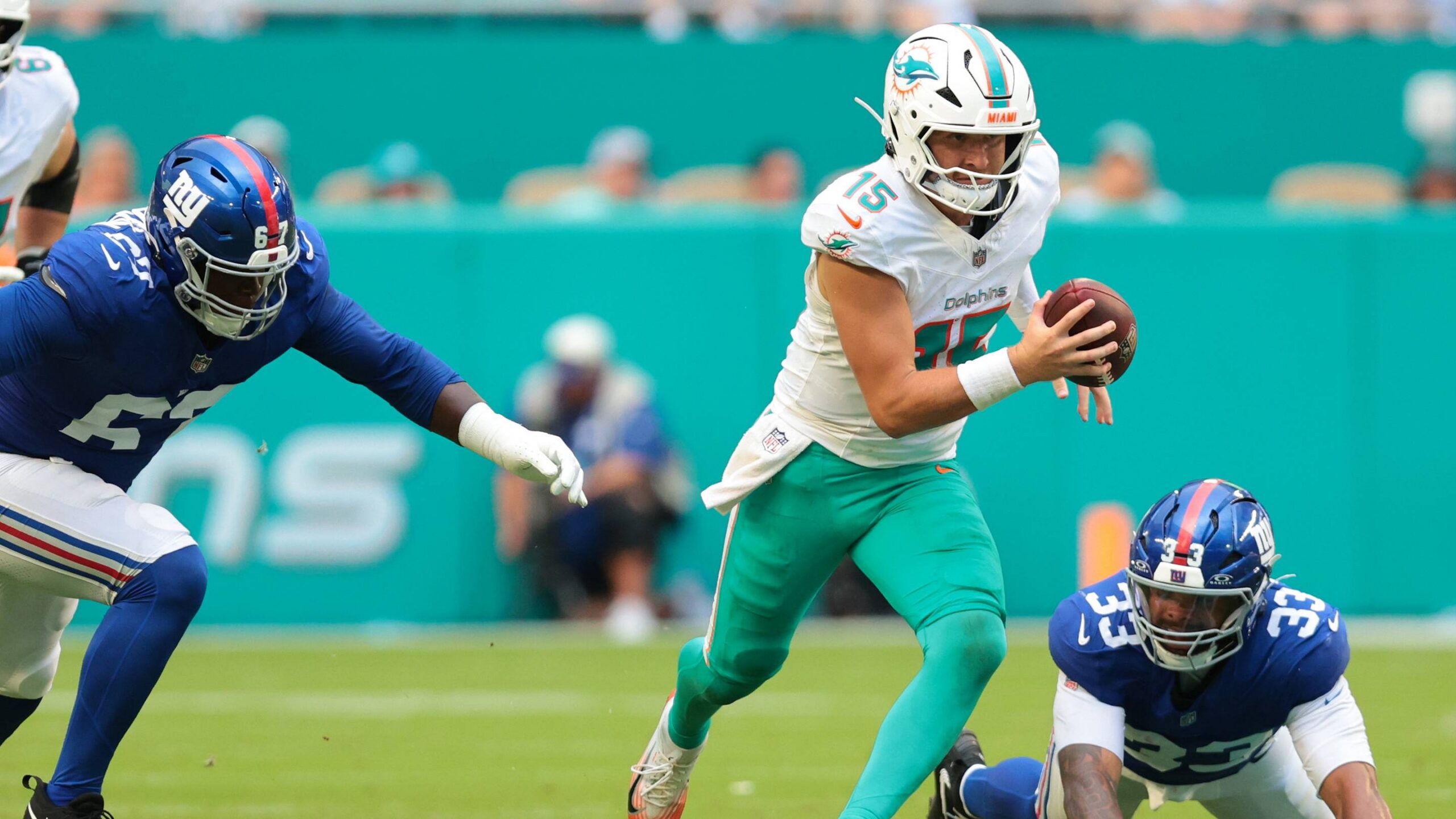 Miami Dolphins quarterback Cam Miller (15) runs with the football against New York Giants linebacker Caleb Murphy (33) and defensive tackle Marlon Davidson (67) during the first half at Hard Rock Stadium.